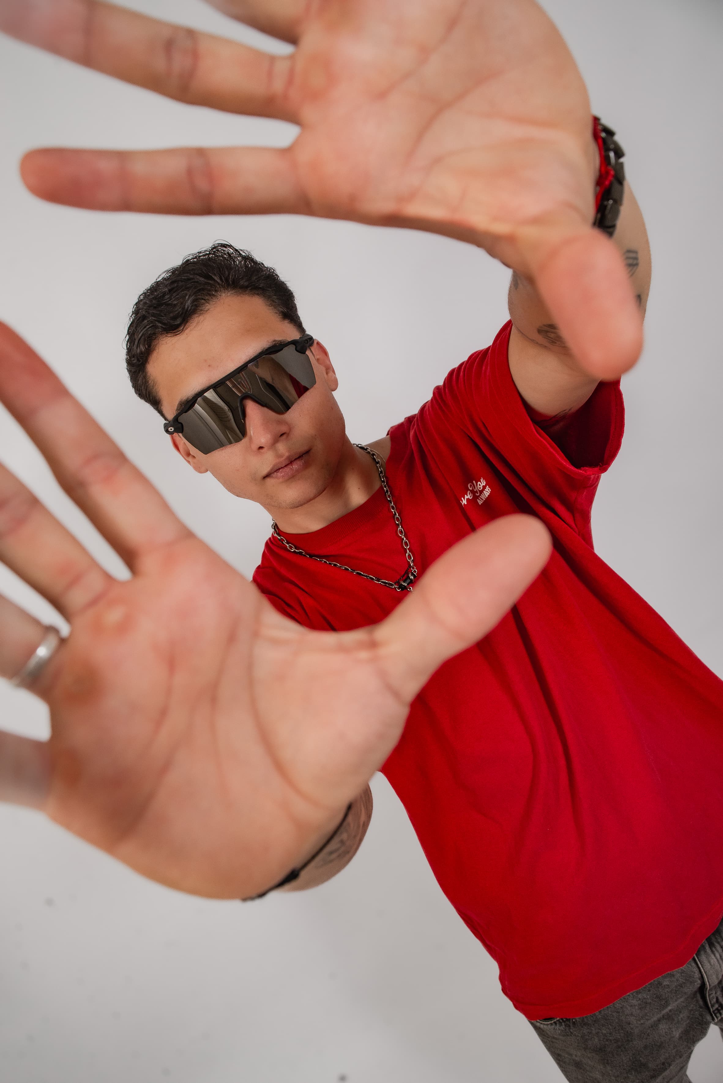 DJ Rubens em ensaio, enquadrando a câmera com as mãos